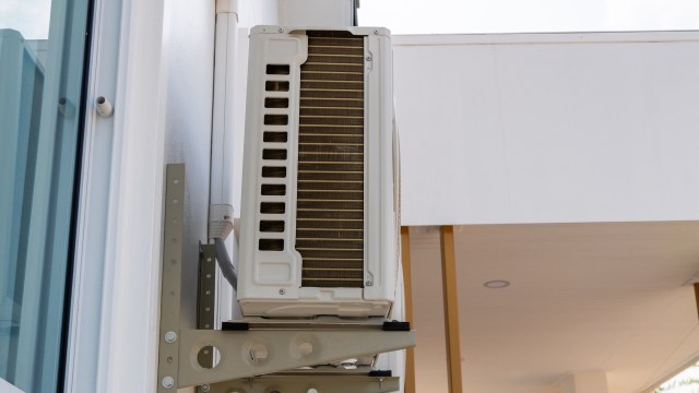 An air conditioning unit mounted on the exterior of a modern building.