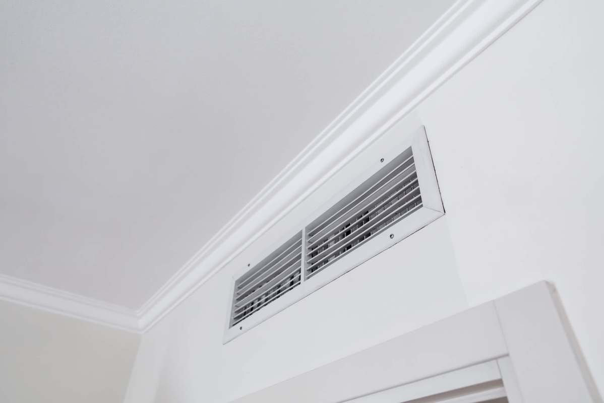 A vent with metal grilles in a wall.