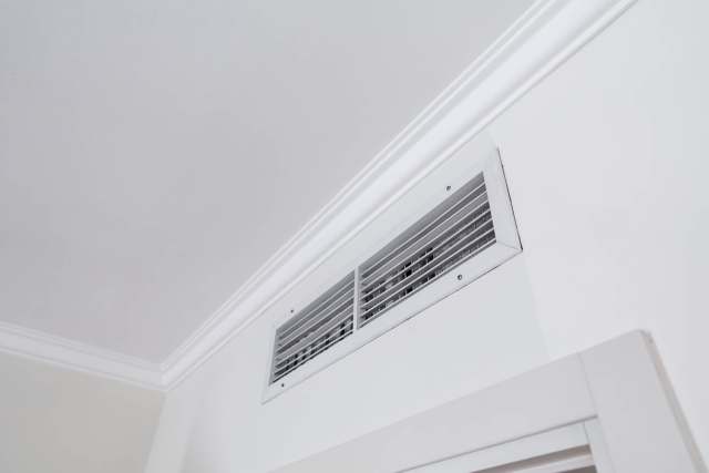 A vent with metal grilles in a wall.