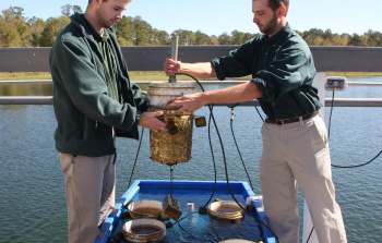 Two workers monitoring aquatic species.