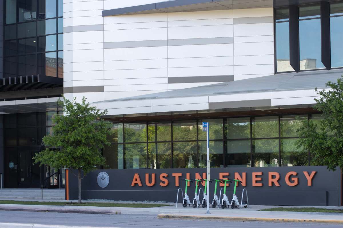 An Austin Energy company building with electric scooters parked outside.