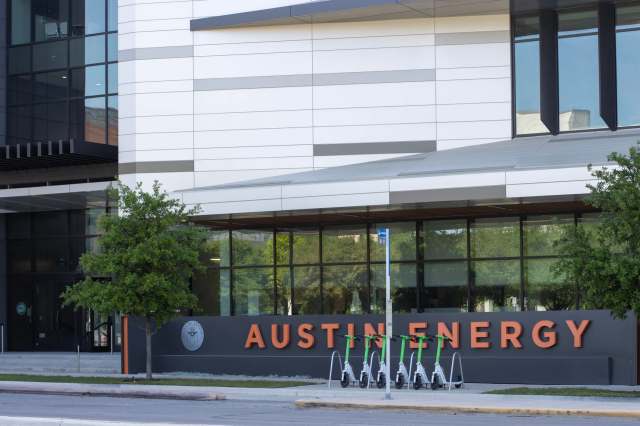 An Austin Energy company building with electric scooters parked outside.