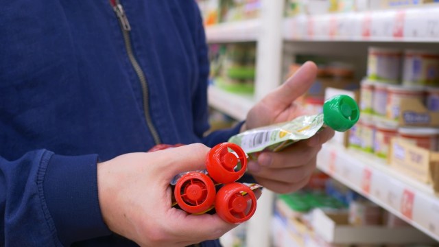 A person holding baby food pouches.