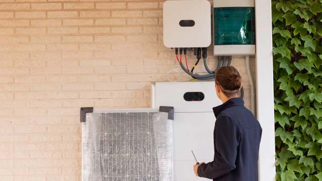 worker installing backup power and solar system