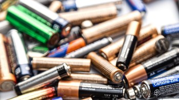 A close-up view of a pile of various batteries, including AA, AAA, and coin cell types.