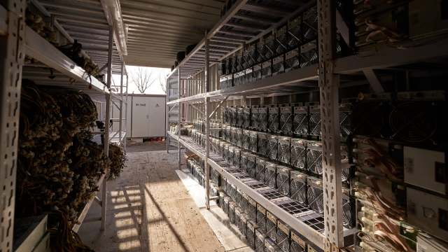 An industrial storage area with shelves filled with mining equipment and tangled power cables.