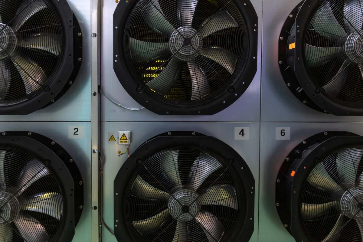 Industrial fans numbered and mounted on a wall.