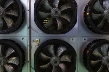 Industrial fans numbered and mounted on a wall.