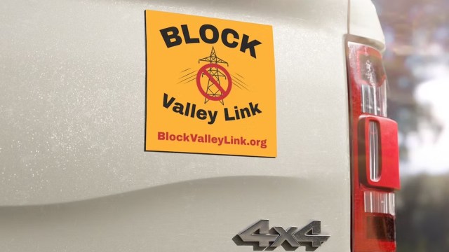 A yellow sticker on a vehicle reads "BLOCK Valley Link" with a no power line symbol and website information.