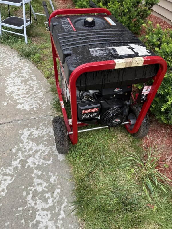 A portable generator next to an outdoor path.