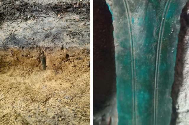 A partially unearthed bronze sword with green patina.