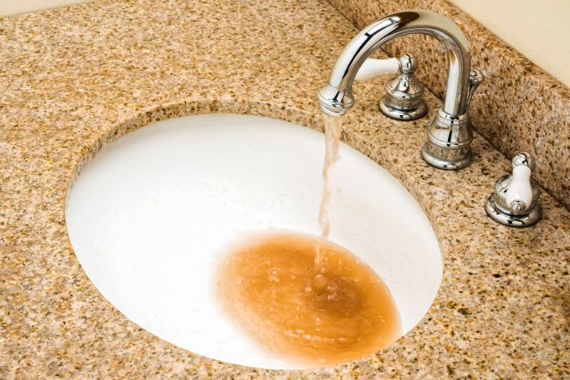 Brown tap water in a sink.