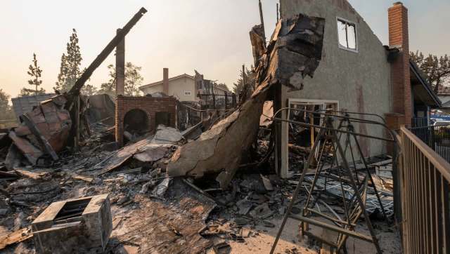 A charred and destroyed house after a wildfire.
