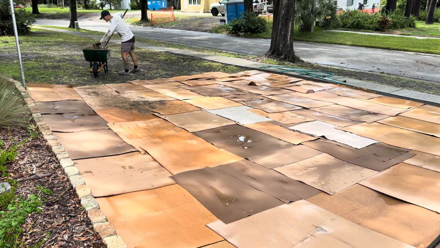A man putting mulch over cardboard.
