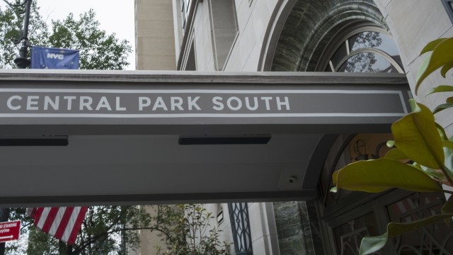 A sign reading "Central Park South" is displayed above an entrance with greenery nearby.