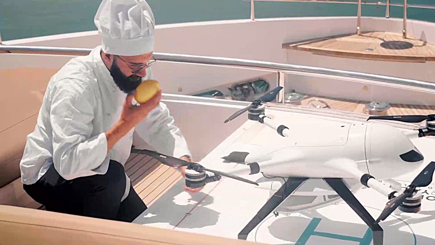 A chef retrieving an item from a drone.