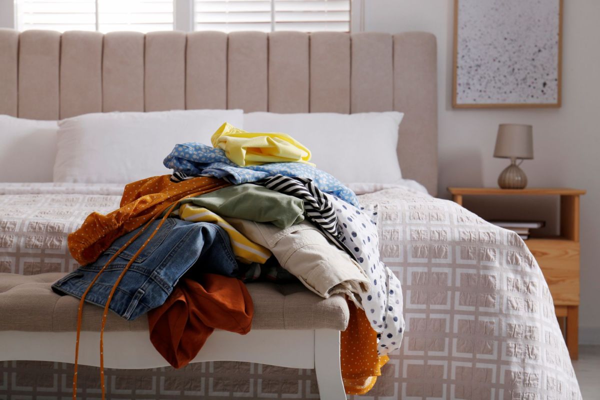 A pile of clothes near a bed.