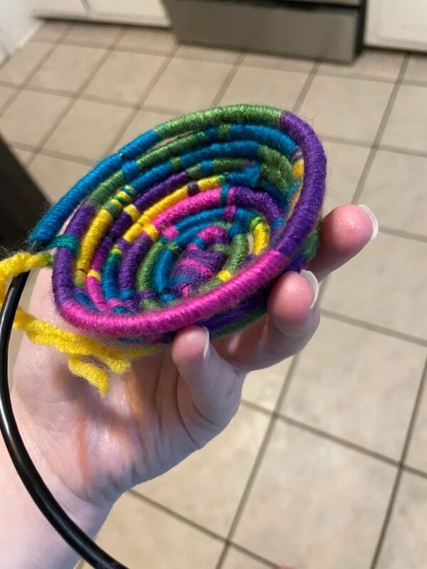 A bowl in the process of being made, with yarn partially wrapped round a cable.