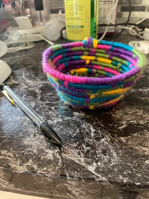 A colorful bowl made of yarn.