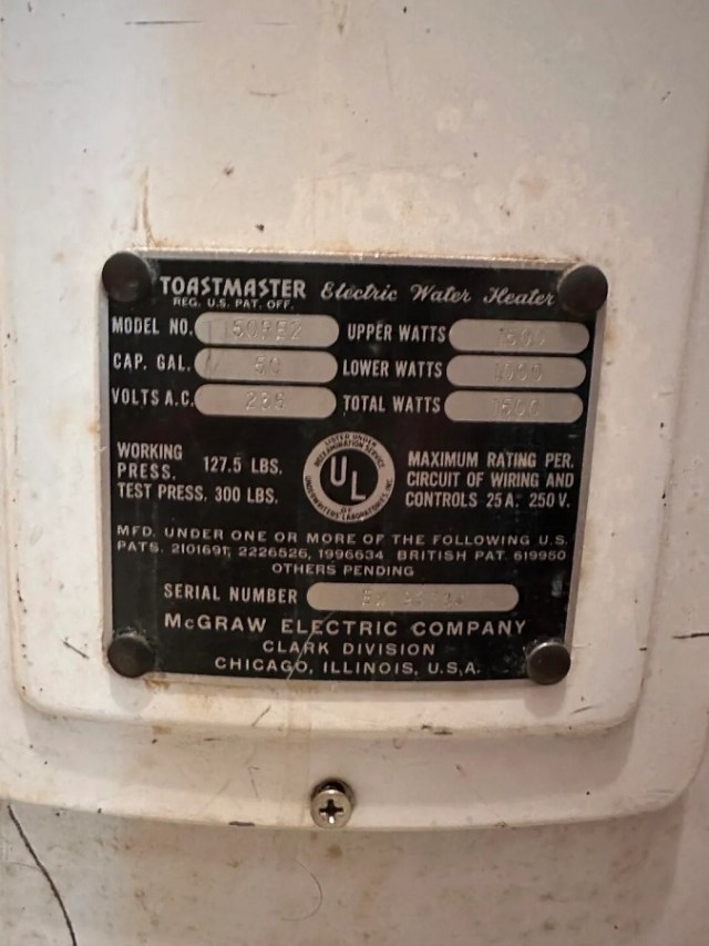 A metal spec plate on a vintage electric water heater.