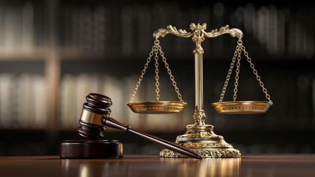 A wooden gavel and a gold balance scale.