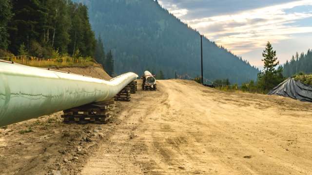 A pipeline running along a dirt road in the mountains.