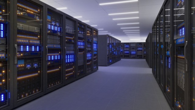 A modern server room featuring racks of servers with glowing blue and orange lights in a sleek, spacious environment.