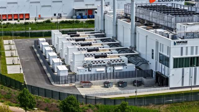 An aerial view of a modern data center featuring large cooling units and storage containers.