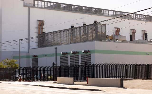 An industrial building with a black fence.