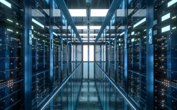 A long corridor between rows of illuminated server racks in a high-tech data center.