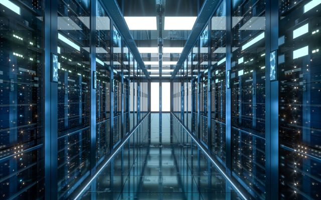 A long corridor between rows of illuminated server racks in a high-tech data center.