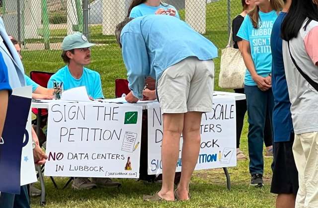 People signing a petition to keep data centers out of Lubbock, Texas.