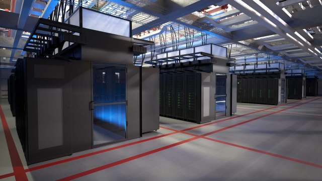 A modern data center featuring rows of black server racks and illuminated areas under a bright ceiling.