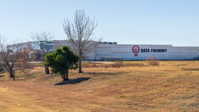 A large industrial building with the sign "DATA FOUNDRY" and dry grassland in the foreground.