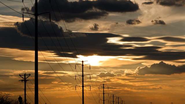 Silhouetted power lines at sunset.