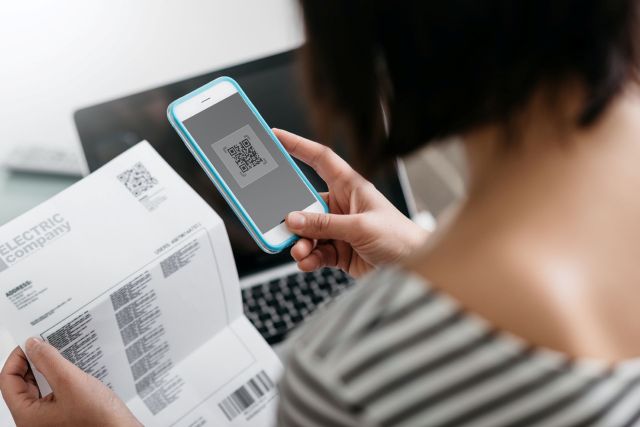 A woman looking at an electric bill.