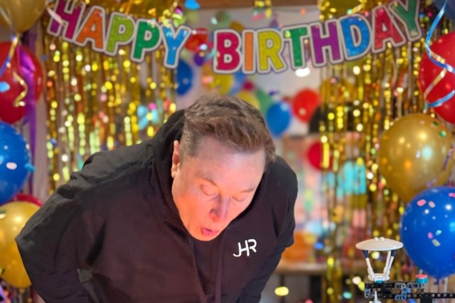 Elon Musk blows out candles at a birthday party.