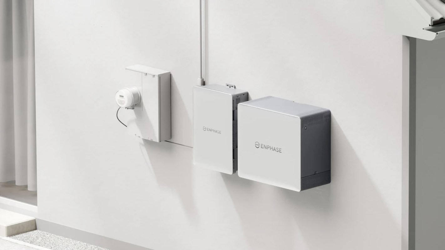 A wall-mounted solar energy system installation featuring Enphase components and a utility meter.