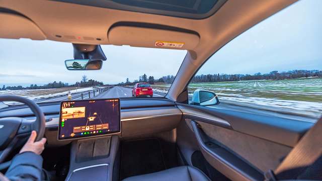 A driver navigating a road in winter.