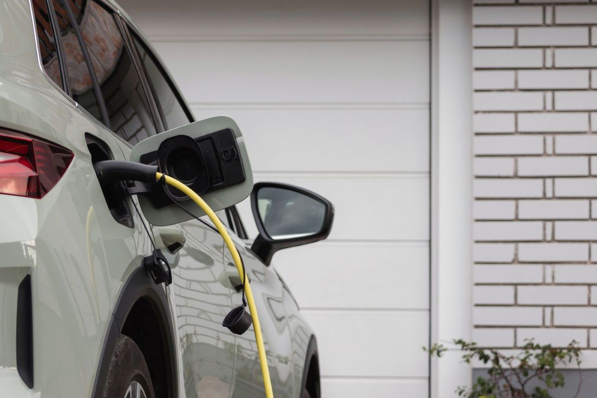 An electric vehicle is plugged in for charging in a garage setting.