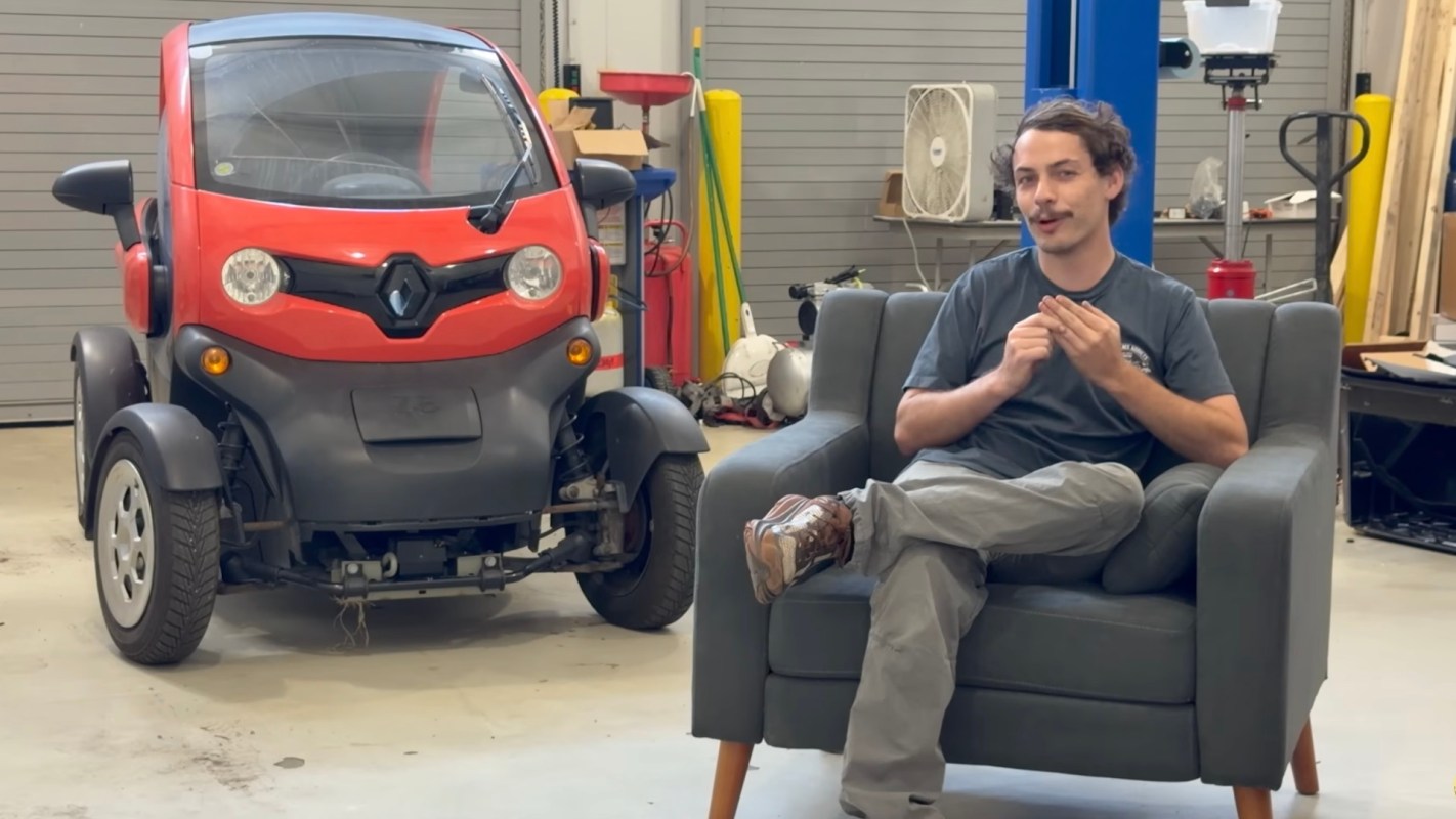 EV repair technician Alex fielding questions in a workshop.