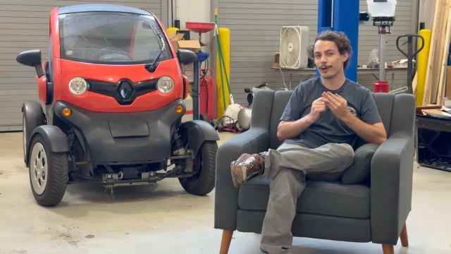 EV repair technician Alex fielding questions in a workshop.