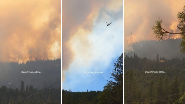 Columns of smoke from a forest fire and a helicopter crew fighting the flames.