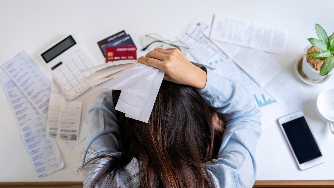 A frustrated person with bills.