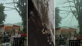 A storm in a backyard with a patio and swing set.