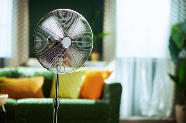 A standing fan in a living room.