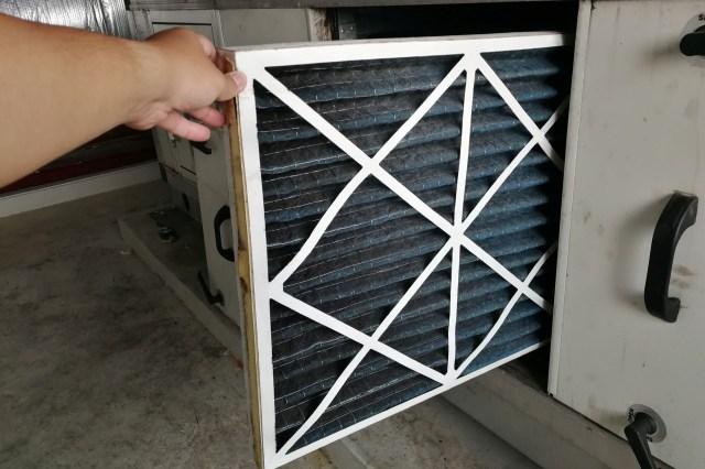 Changing the filter in an HVAC unit.
