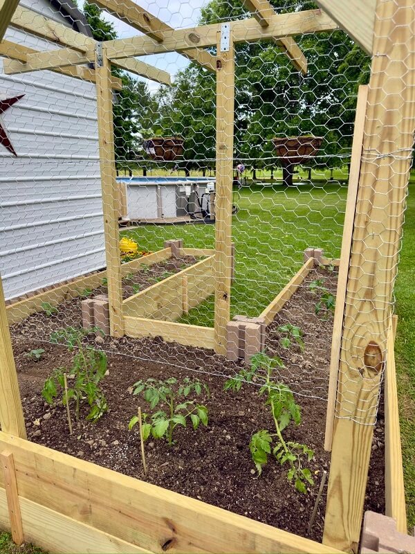 U-shaped garden bed with dirt in it on a bright sunny day with mountains in the background