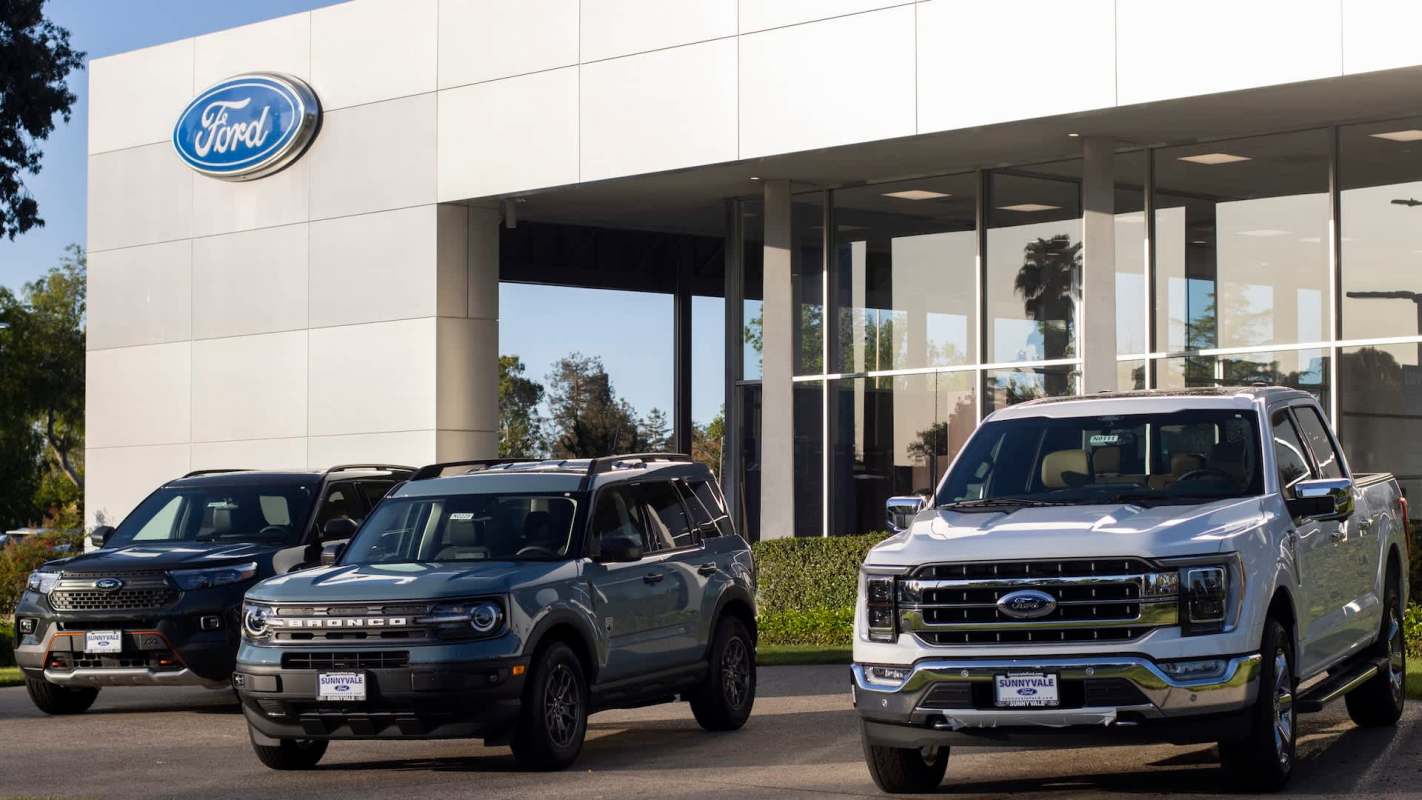 Vehicles in front of a Ford dealership.