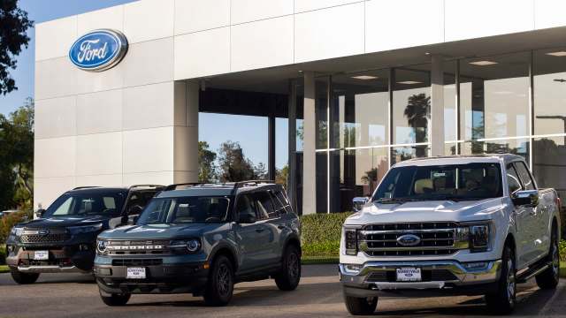 Vehicles in front of a Ford dealership.